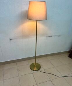 A modern and elegant floor lamp (lampade) with a slim, copper-gold metal base and a warm fabric shade. - Image 2