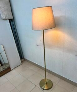 A modern and elegant floor lamp (lampade) with a slim, copper-gold metal base and a warm fabric shade. - Image 4