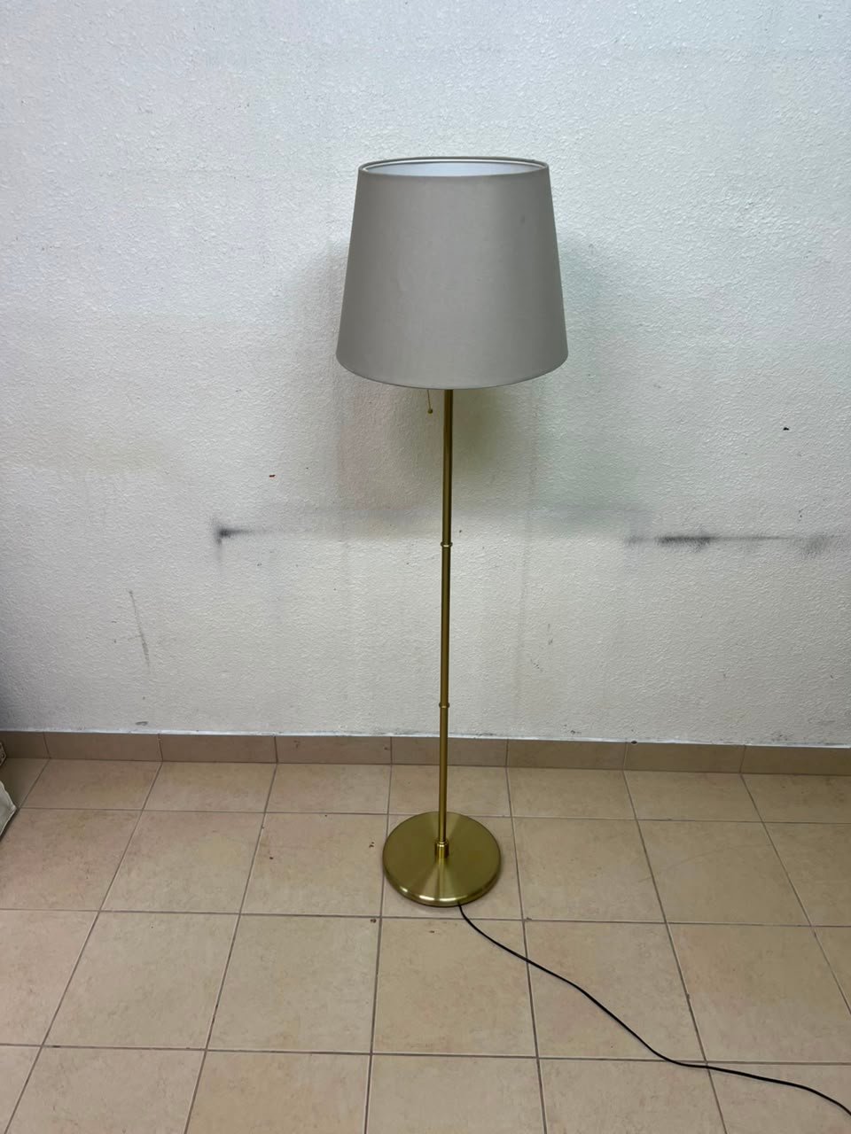A modern and elegant floor lamp (lampade) with a slim, copper-gold metal base and a warm fabric shade. - Image 7