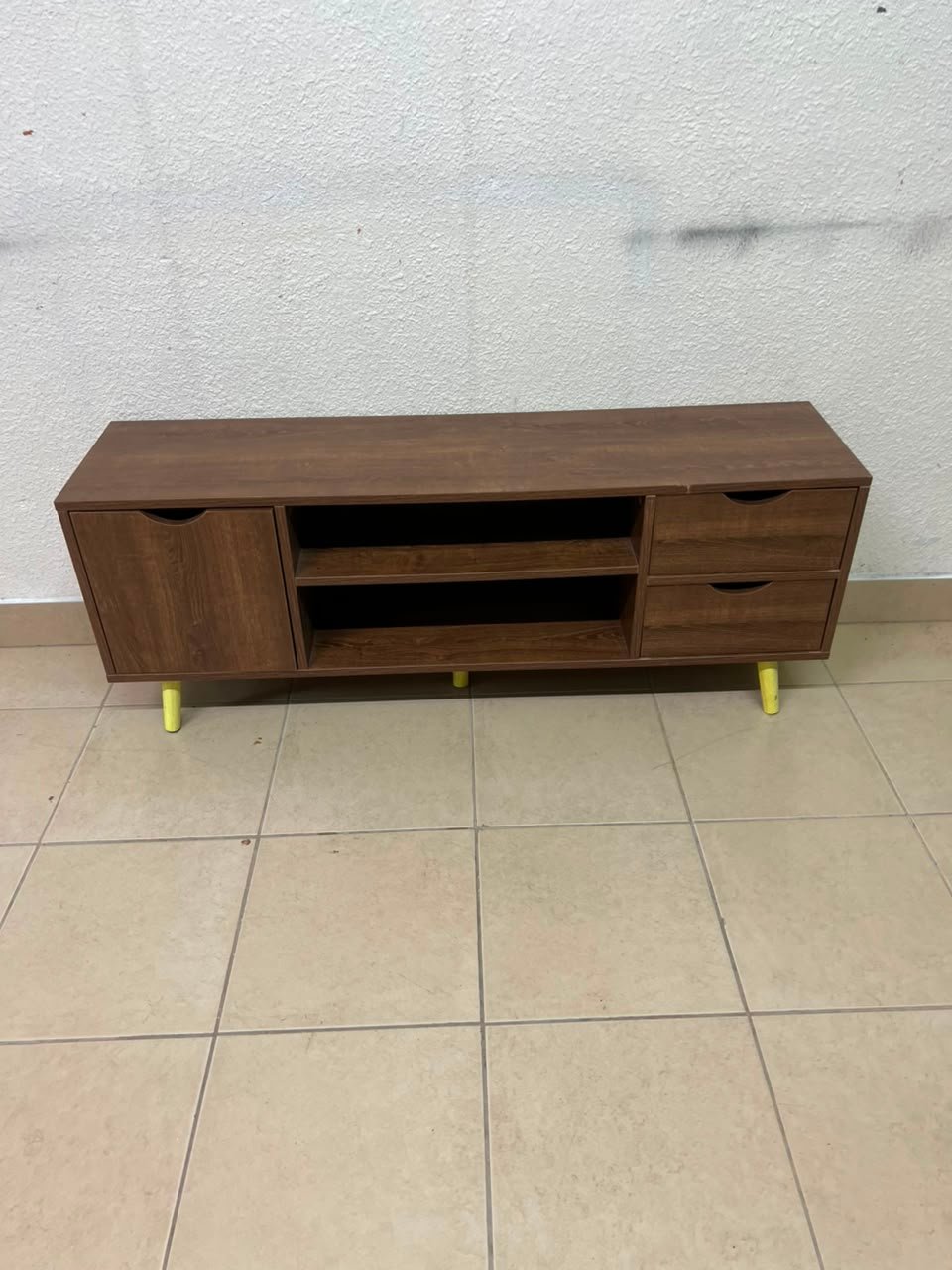 A Mid-Century Modern wood-design TV unit featuring open cabinets and shelves, side drawers, and distinctive legs.