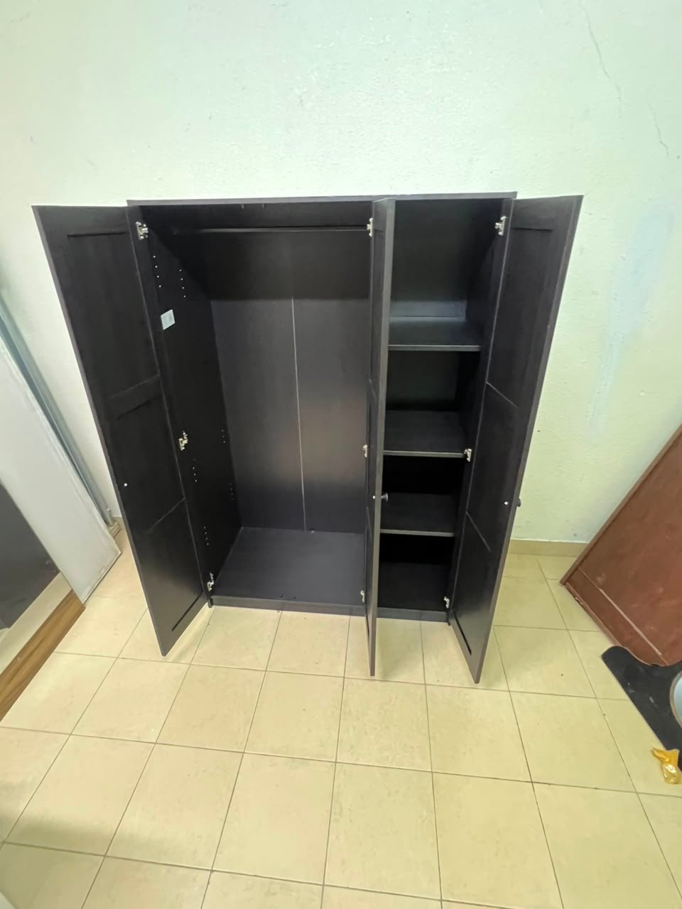 The RAKKESTAD wardrobe from IKEA has three doors and comes in a black-brown color, measuring 117x176 cm. - Image 3