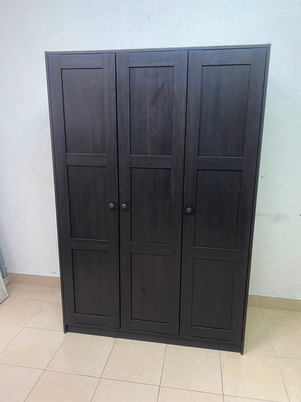 The RAKKESTAD wardrobe from IKEA has three doors and comes in a black-brown color, measuring 117x176 cm. - Image 6