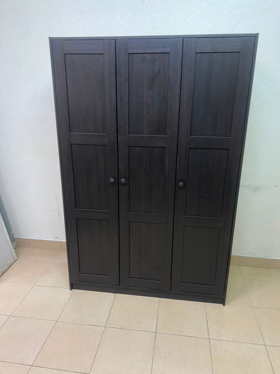 The RAKKESTAD wardrobe from IKEA has three doors and comes in a black-brown color, measuring 117x176 cm. - Image 12
