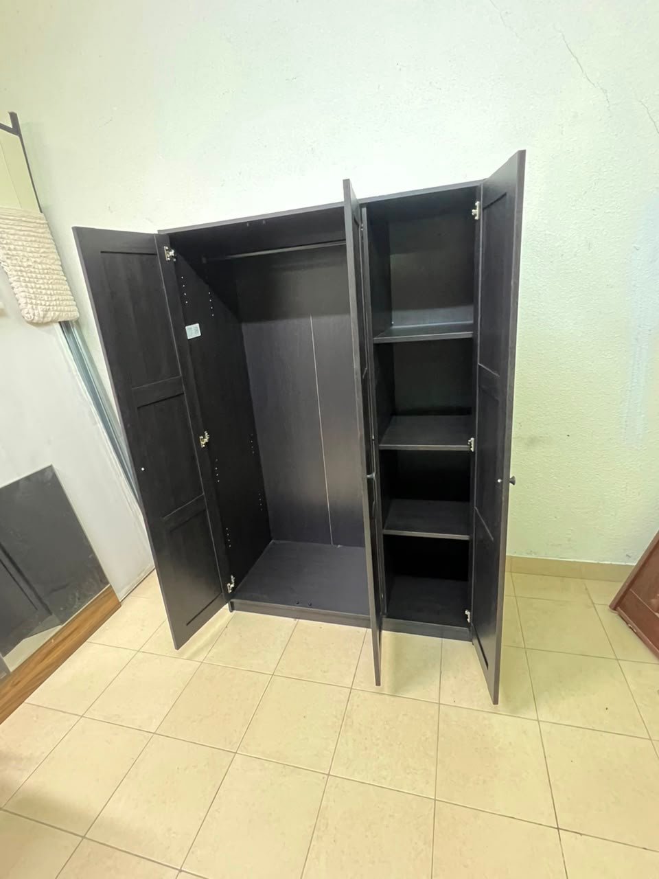 The RAKKESTAD wardrobe from IKEA has three doors and comes in a black-brown color, measuring 117x176 cm. - Image 7
