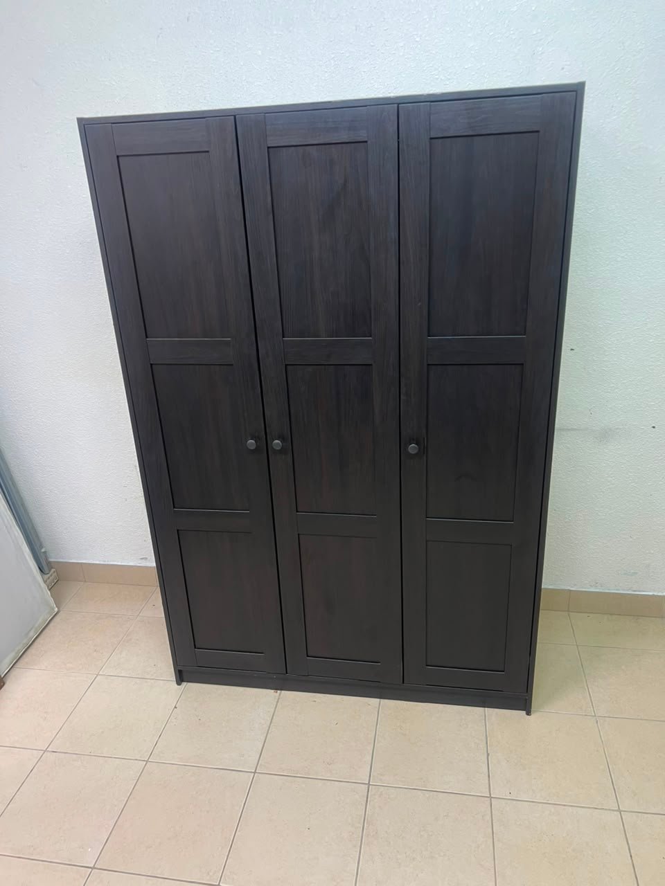 The RAKKESTAD wardrobe from IKEA has three doors and comes in a black-brown color, measuring 117x176 cm. - Image 8