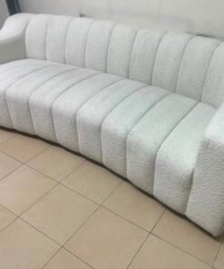 With the cream-colored Eichholtz Kelly Bouclé sofa, which features a distinctive design with signature vertical stitching and soft-touch upholstery.
