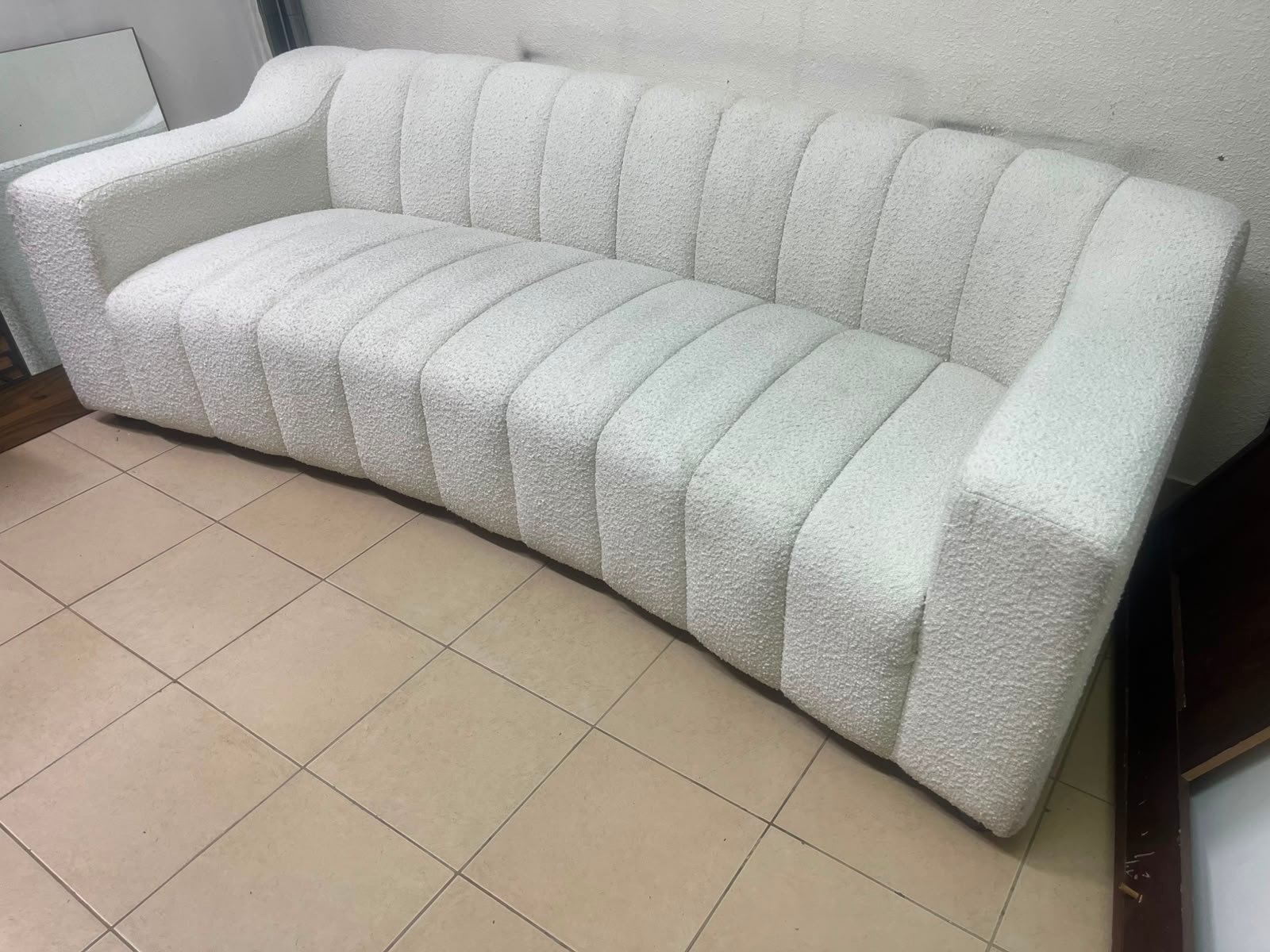 With the cream-colored Eichholtz Kelly Bouclé sofa, which features a distinctive design with signature vertical stitching and soft-touch upholstery.