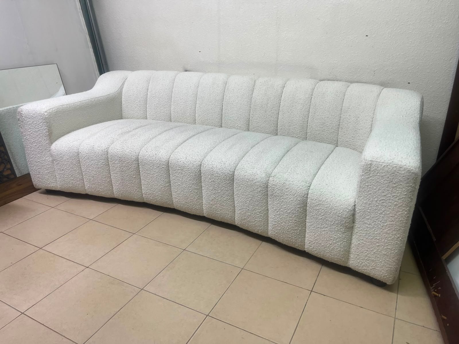 With the cream-colored Eichholtz Kelly Bouclé sofa, which features a distinctive design with signature vertical stitching and soft-touch upholstery. - Image 6