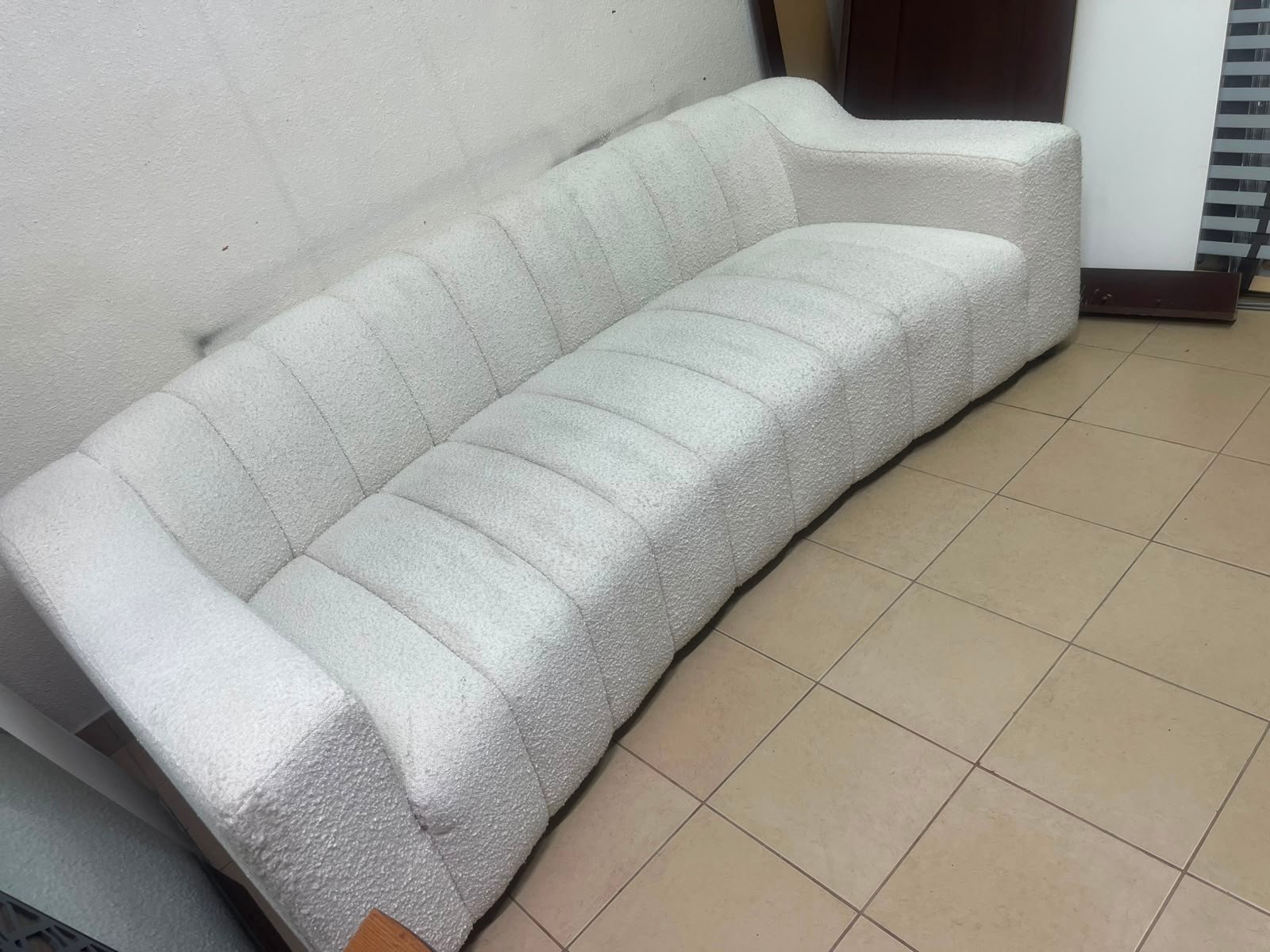 With the cream-colored Eichholtz Kelly Bouclé sofa, which features a distinctive design with signature vertical stitching and soft-touch upholstery. - Image 2