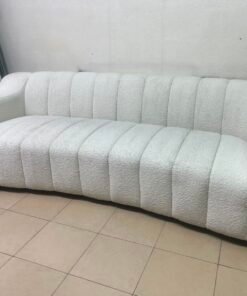 With the cream-colored Eichholtz Kelly Bouclé sofa, which features a distinctive design with signature vertical stitching and soft-touch upholstery. - Image 5