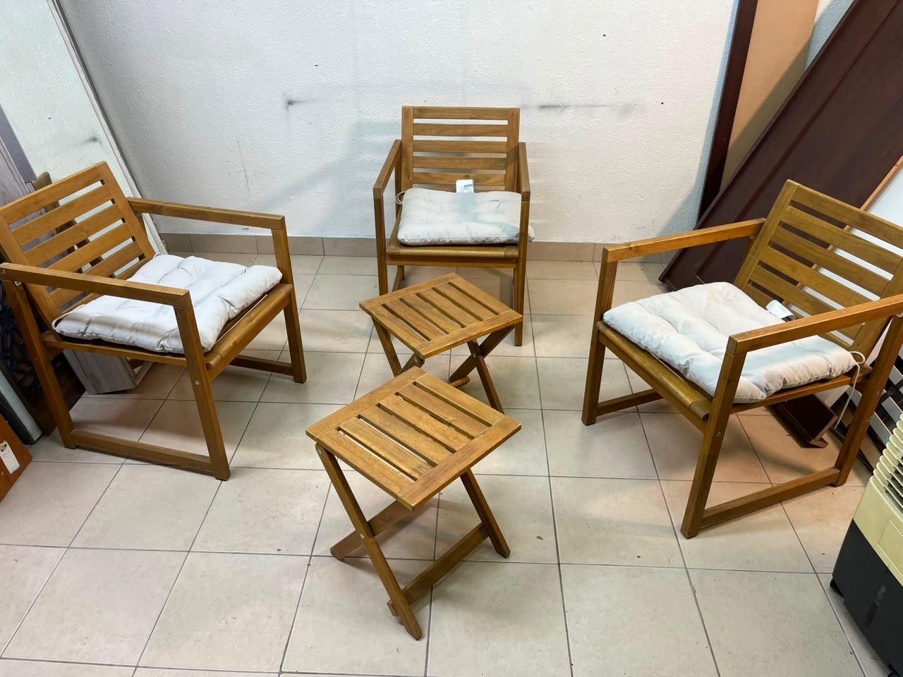 displays the IKEA NÄMMARÖ light brown stained outdoor armchairs and matching folding tables paired with KUDDARNA light gray-beige cushions. - Image 2