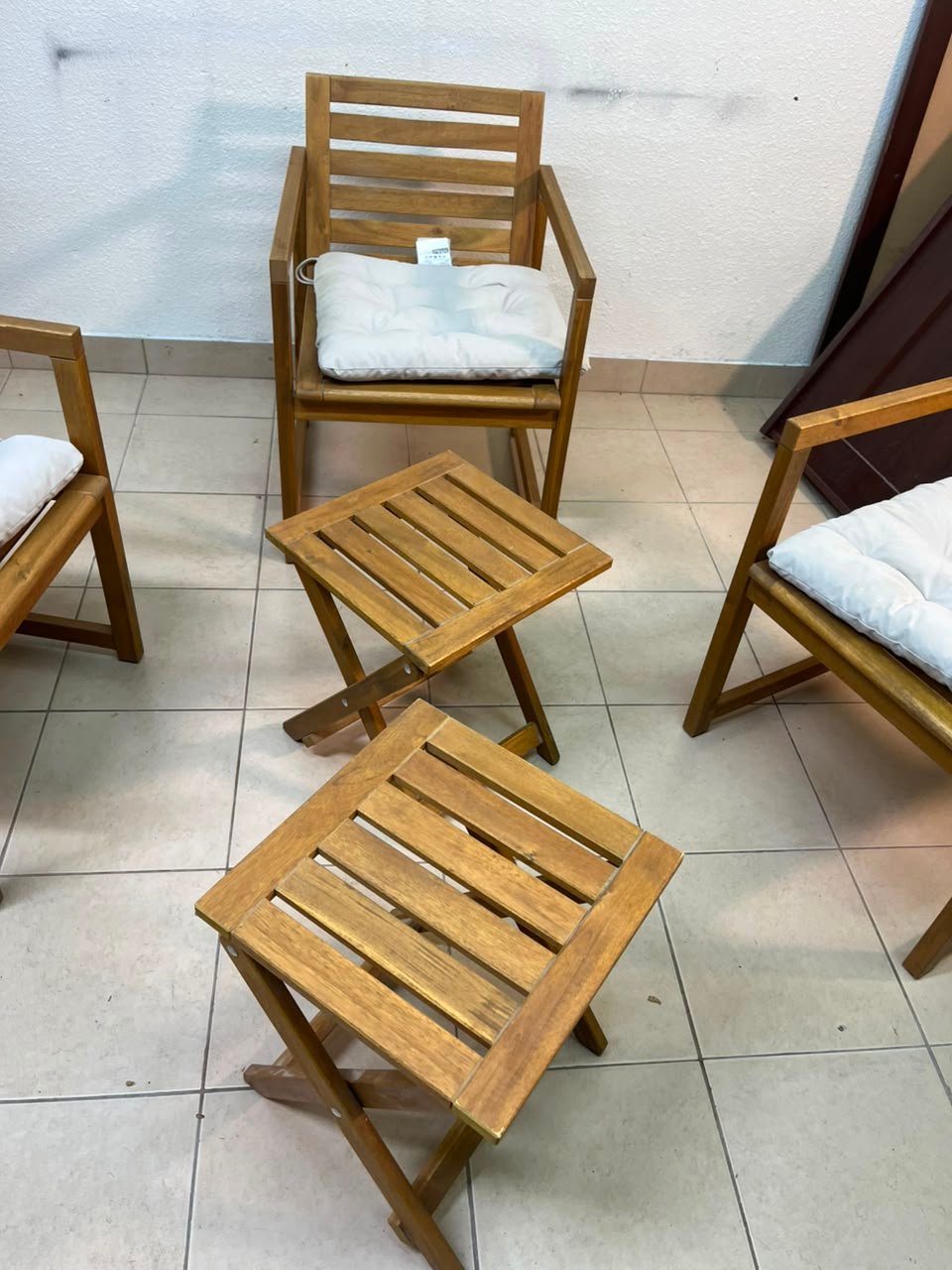 displays the IKEA NÄMMARÖ light brown stained outdoor armchairs and matching folding tables paired with KUDDARNA light gray-beige cushions. - Image 6