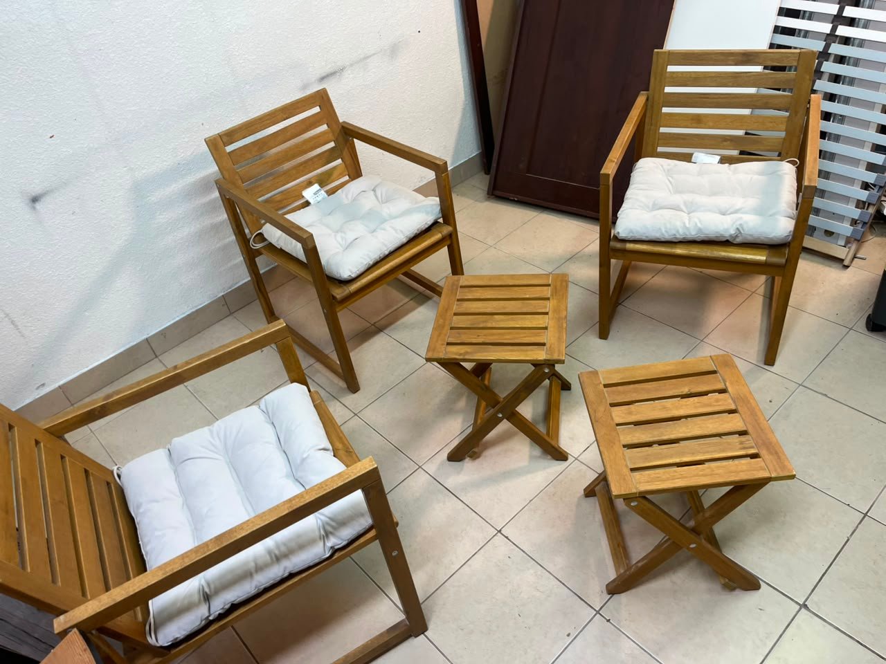 displays the IKEA NÄMMARÖ light brown stained outdoor armchairs and matching folding tables paired with KUDDARNA light gray-beige cushions. - Image 8