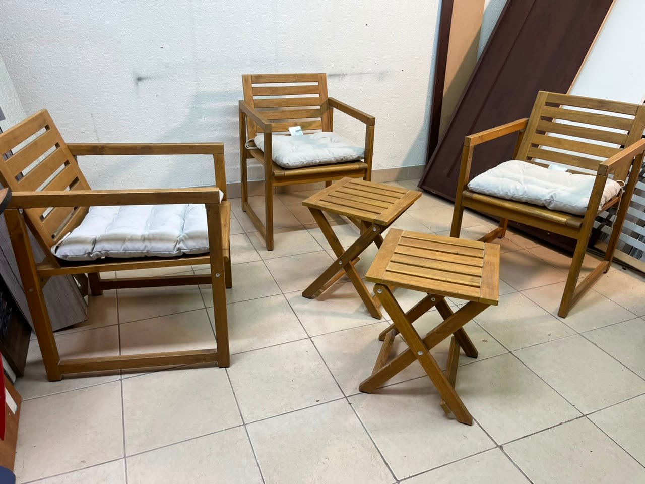 displays the IKEA NÄMMARÖ light brown stained outdoor armchairs and matching folding tables paired with KUDDARNA light gray-beige cushions. - Image 4