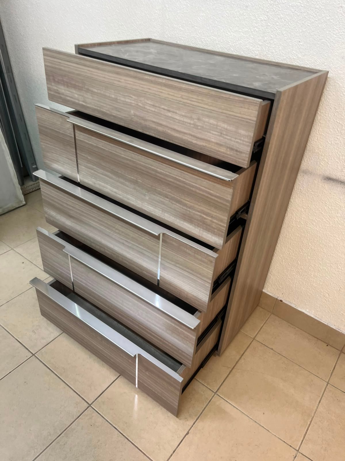 The Warner Chest of 5-Drawers from Homecentre features a beige and caramel walnut finish with distinct long metallic handles. - Image 11