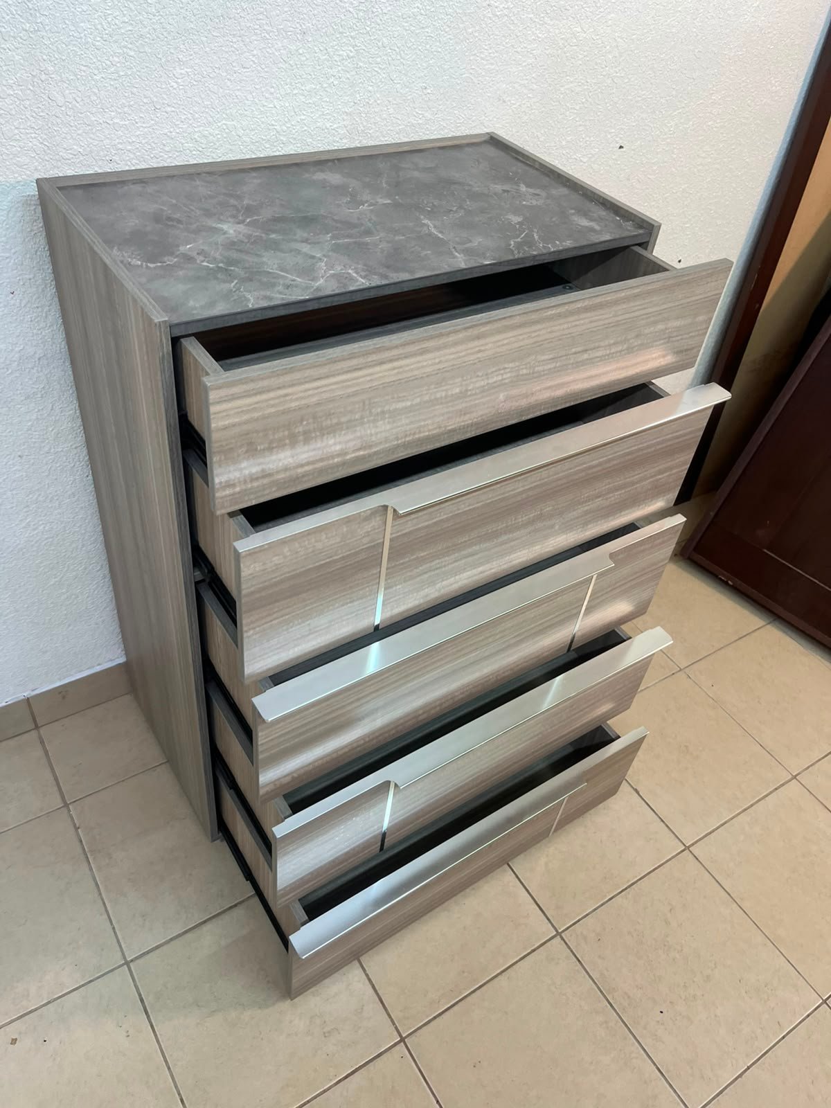 The Warner Chest of 5-Drawers from Homecentre features a beige and caramel walnut finish with distinct long metallic handles. - Image 9