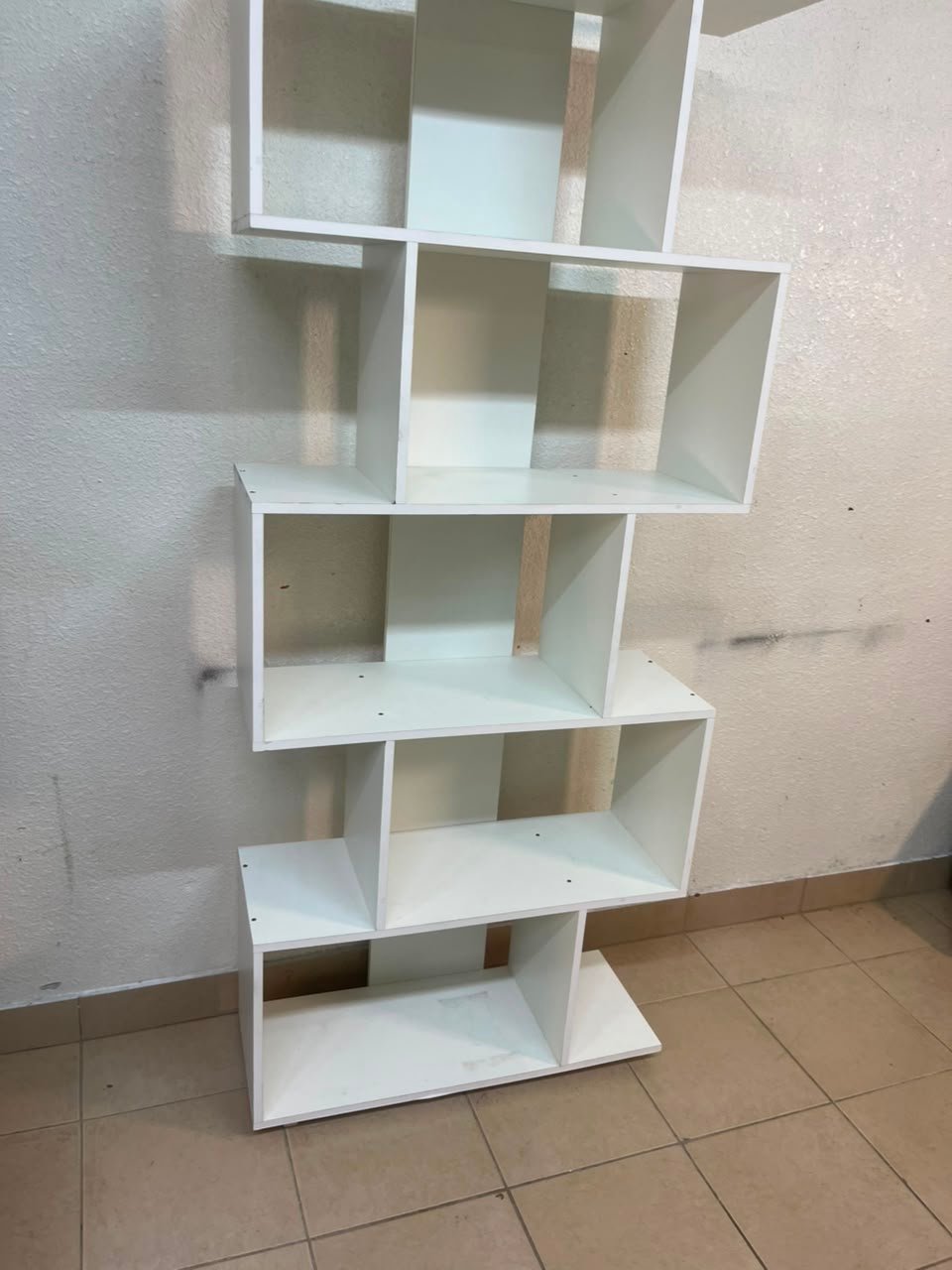 This white 5-tier geometric S-shaped bookshelf functions as an open display rack or room divider. - Image 12