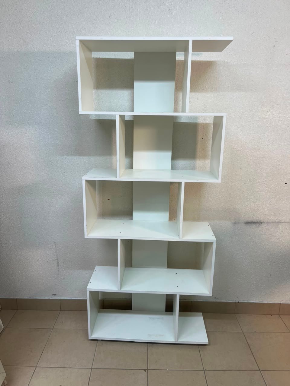 This white 5-tier geometric S-shaped bookshelf functions as an open display rack or room divider. - Image 2