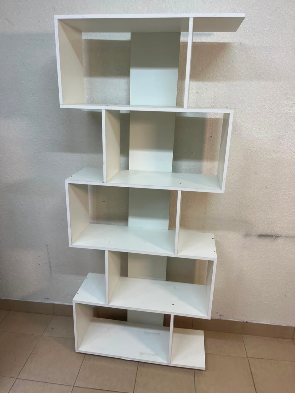 This white 5-tier geometric S-shaped bookshelf functions as an open display rack or room divider. - Image 8