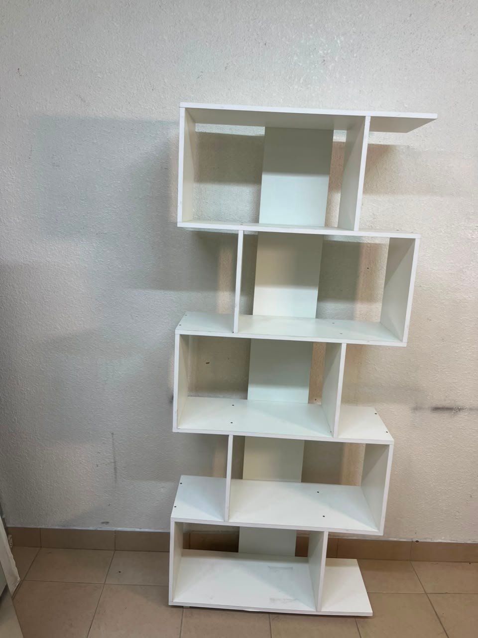 This white 5-tier geometric S-shaped bookshelf functions as an open display rack or room divider. - Image 10