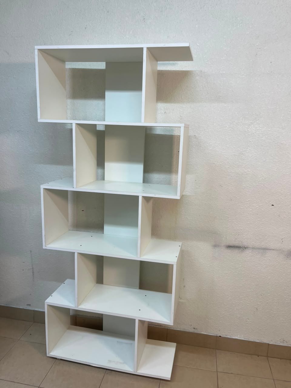 This white 5-tier geometric S-shaped bookshelf functions as an open display rack or room divider. - Image 4