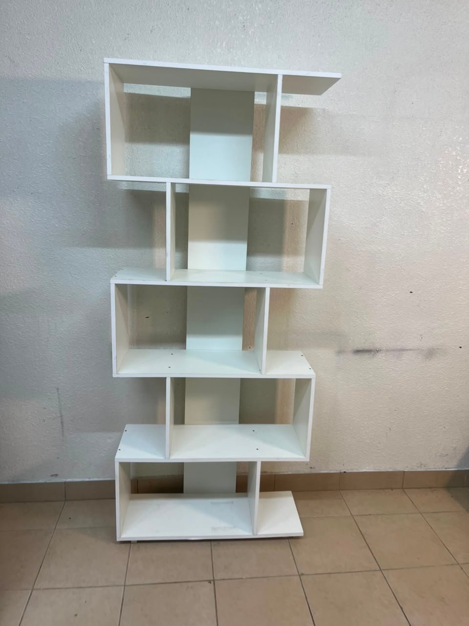 This white 5-tier geometric S-shaped bookshelf functions as an open display rack or room divider. - Image 3