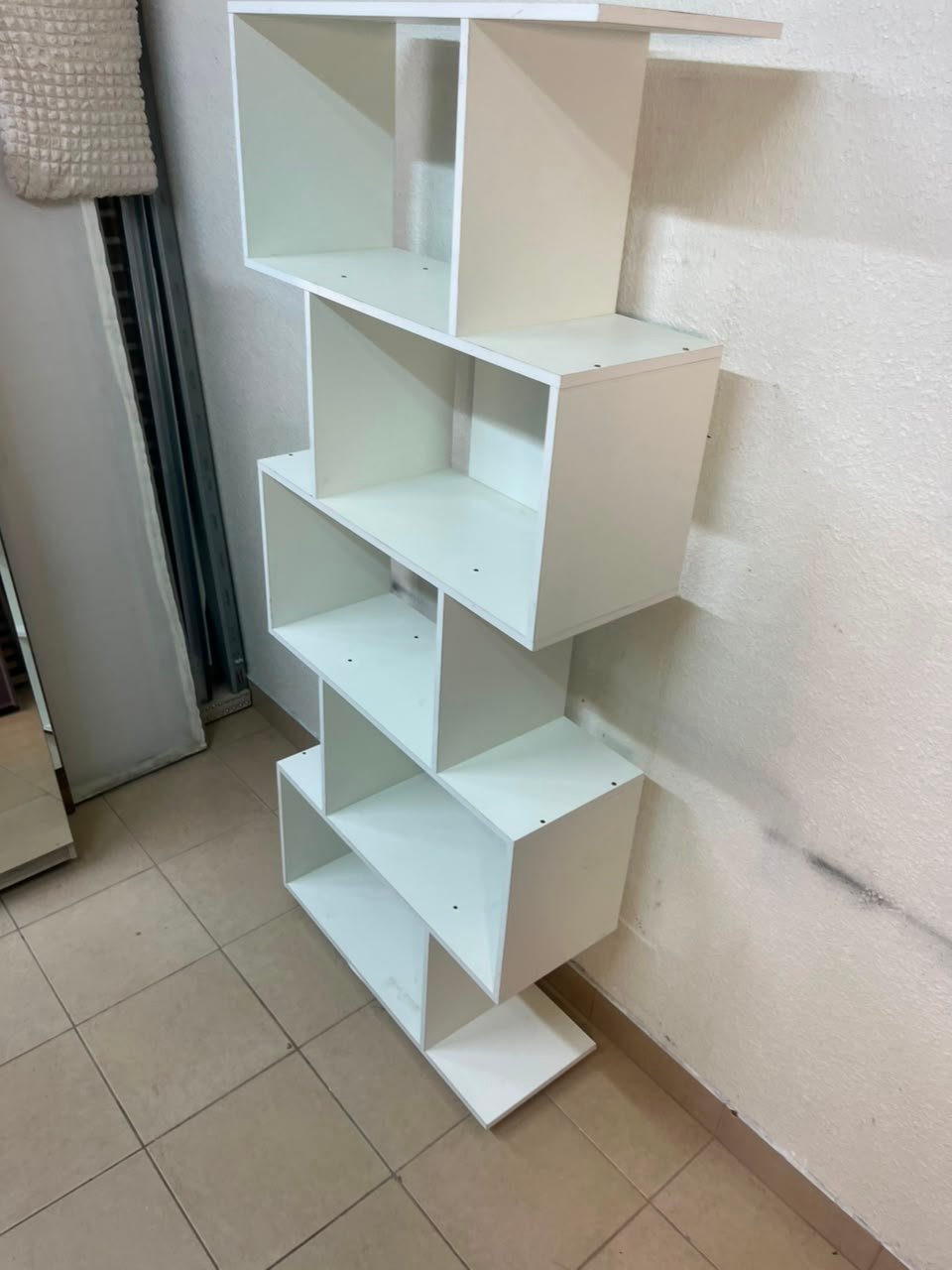 This white 5-tier geometric S-shaped bookshelf functions as an open display rack or room divider. - Image 5