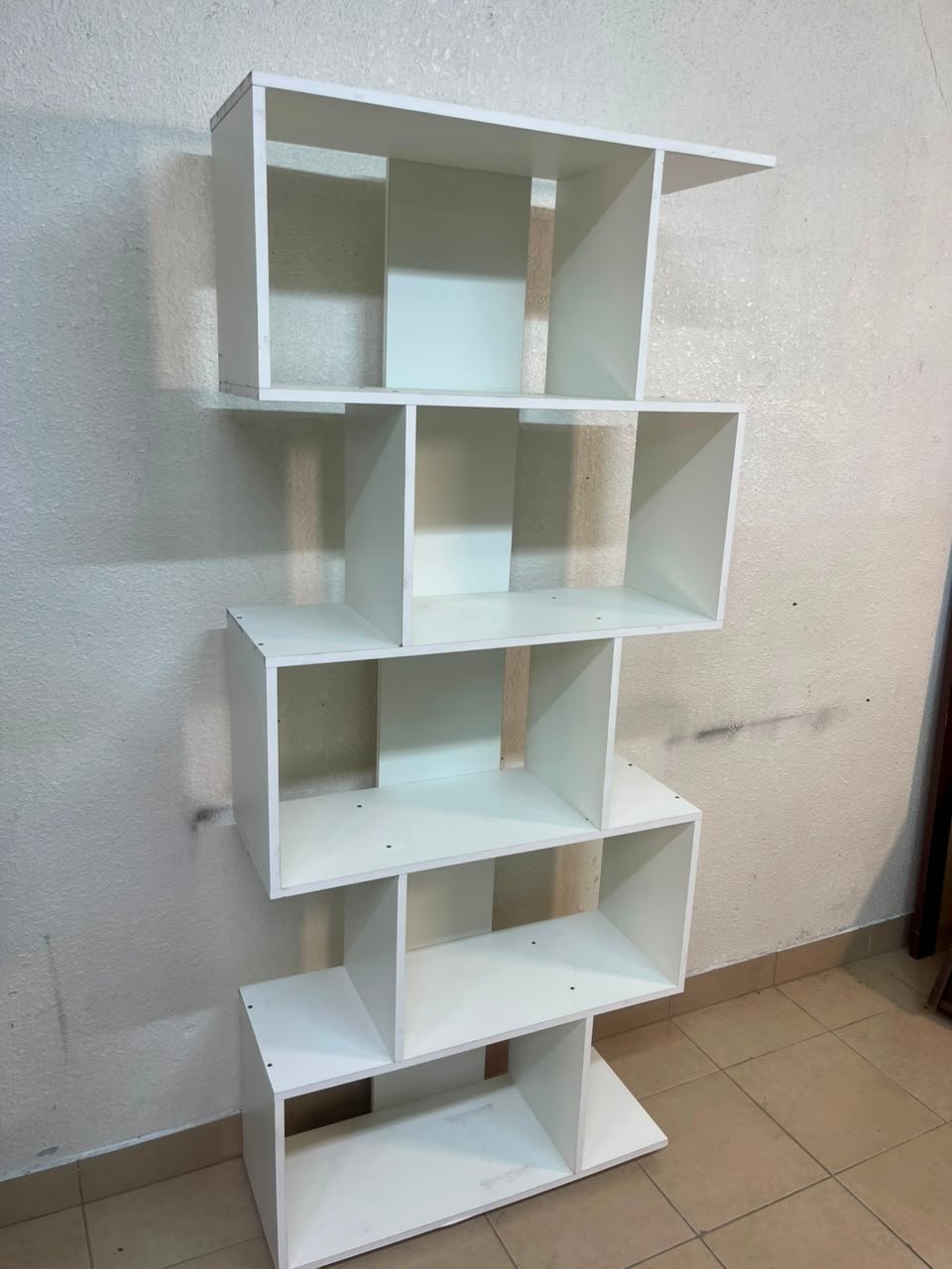 This white 5-tier geometric S-shaped bookshelf functions as an open display rack or room divider. - Image 14