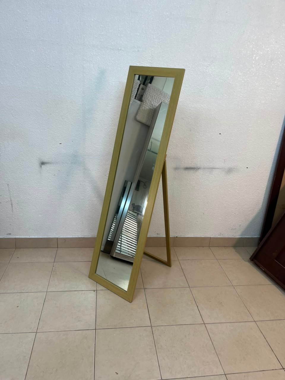 A mirror with a gold frame and a sturdy back stand on which the base is frequently mounted (Cheval Floor Mirror).