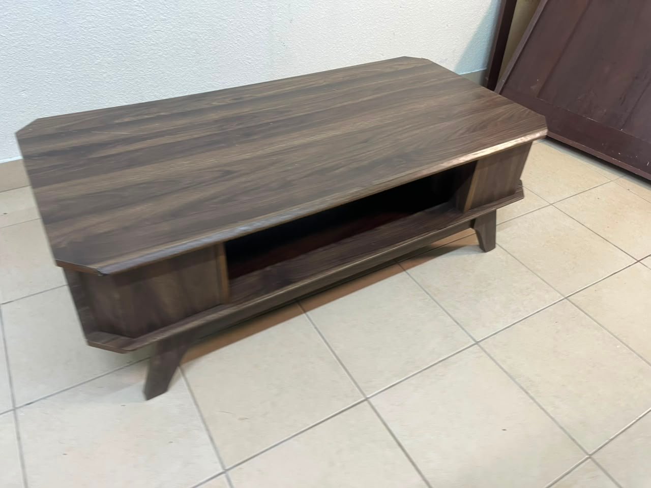 Tough-wearing walnut-finish wooden coffee table featuring a rectangular top, lower storage shelf, and subtle corner detailing.