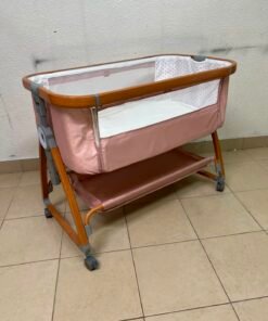 Portable Baby Bassinet / Co-Sleeper Crib with Lockable Wheels – Pink Fabric, Mesh Side Panels, Wood-Tone Frame & Under-Bed Storage Shelf