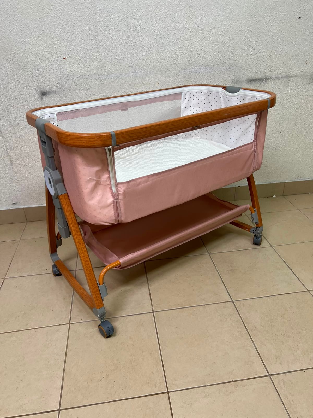 Portable Baby Bassinet / Co-Sleeper Crib with Lockable Wheels – Pink Fabric, Mesh Side Panels, Wood-Tone Frame & Under-Bed Storage Shelf
