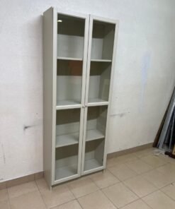 A bookcase with a glass door from IKEA, specifically from the BILLY/OXBERG series in white.