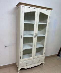 An antique-style display cabinet (vitrine) with two glass doors and an ivory frame with a wooden top.
