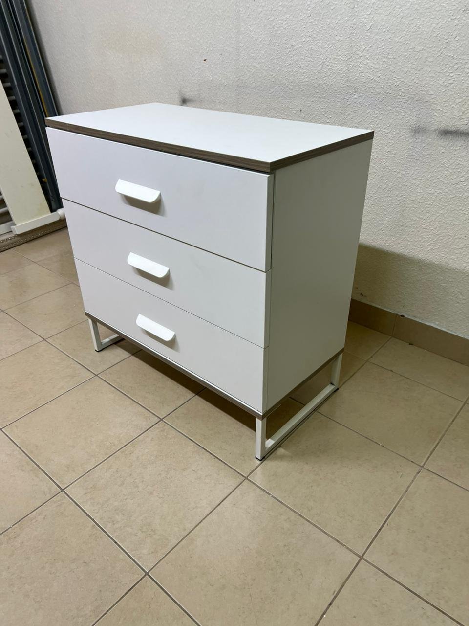 White chest of drawers with three drawers and metal legs with a connected frame. - Image 3