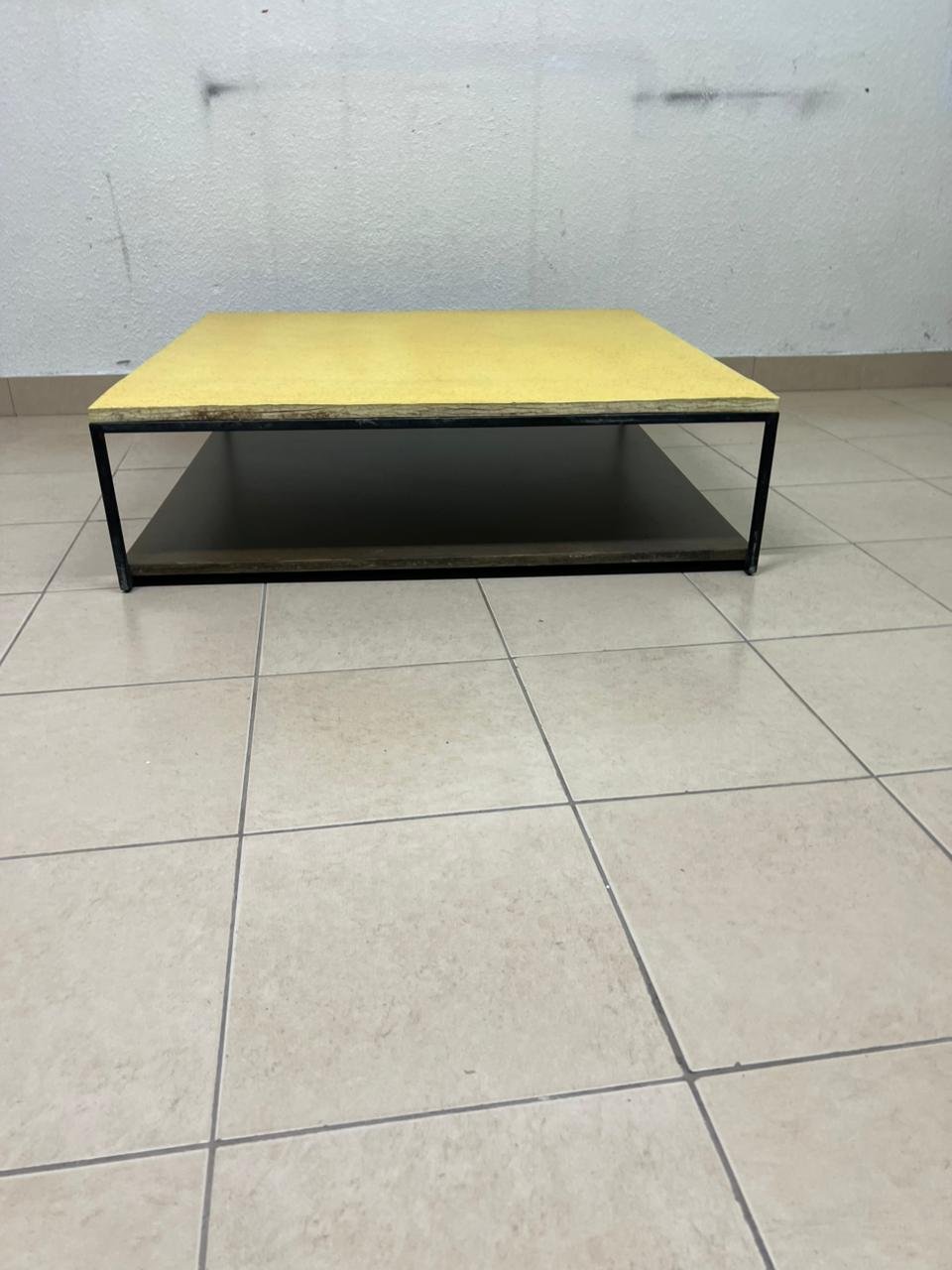 This is a square coffee table with an industrial design, featuring a black metal frame, a black pull-out drawer or lower shelf, and a light yellow wooden top. - Image 7