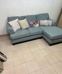 This is a light blue fabric corner sofa featuring a comfortable design with various cushions. - Image 5