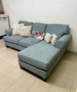 This is a light blue fabric corner sofa featuring a comfortable design with various cushions. - Image 10