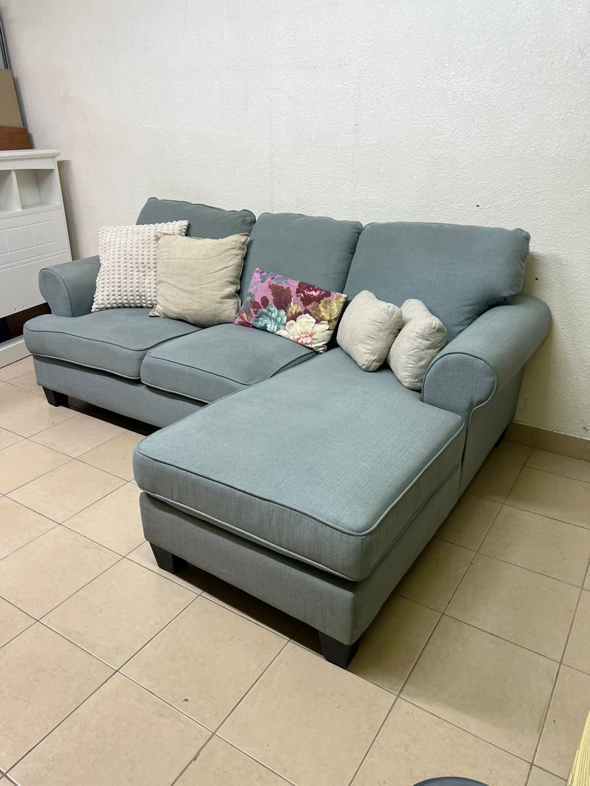 This is a light blue fabric corner sofa featuring a comfortable design with various cushions. - Image 10