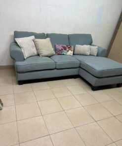 This is a light blue fabric corner sofa featuring a comfortable design with various cushions.