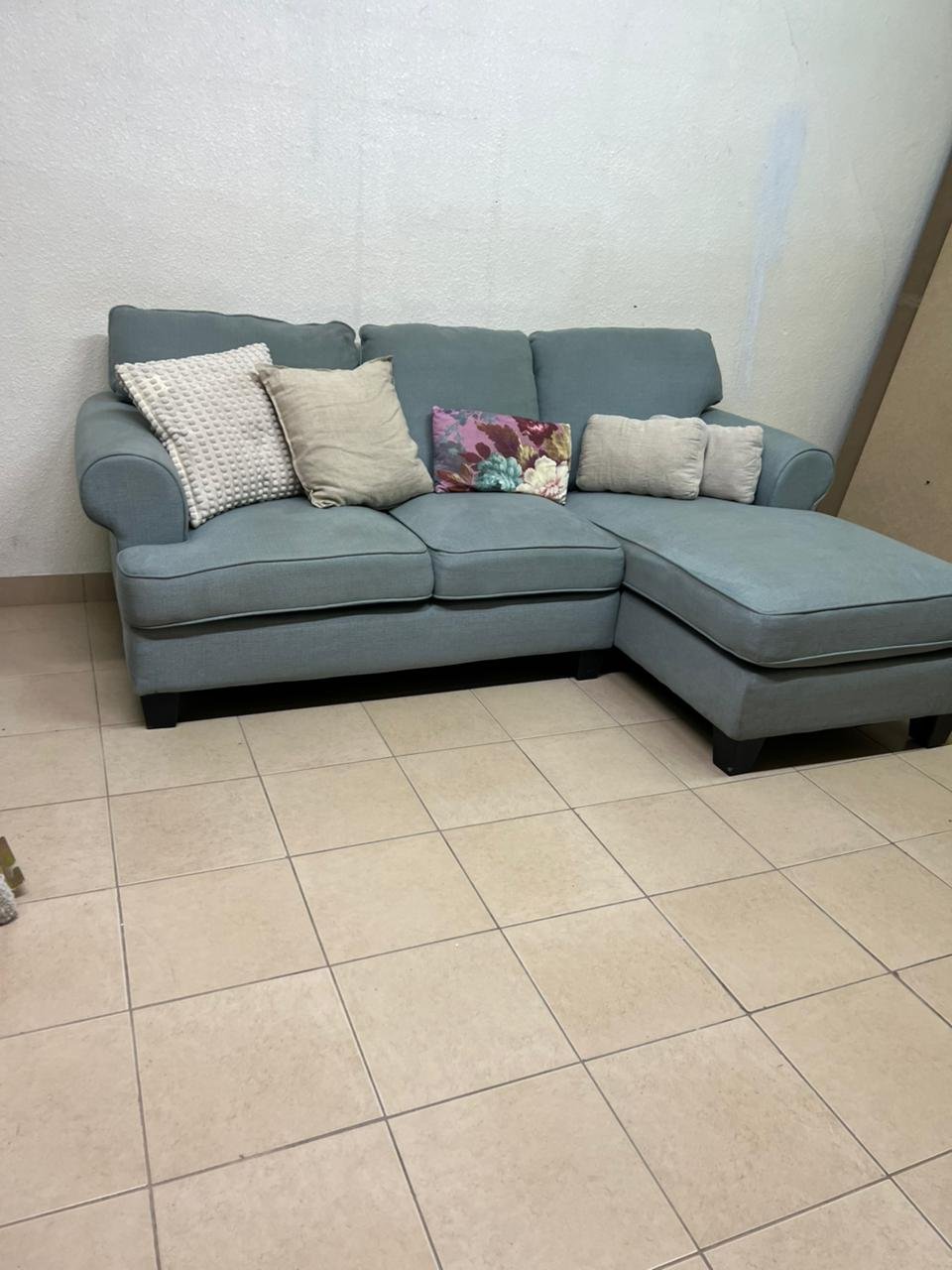 This is a light blue fabric corner sofa featuring a comfortable design with various cushions.