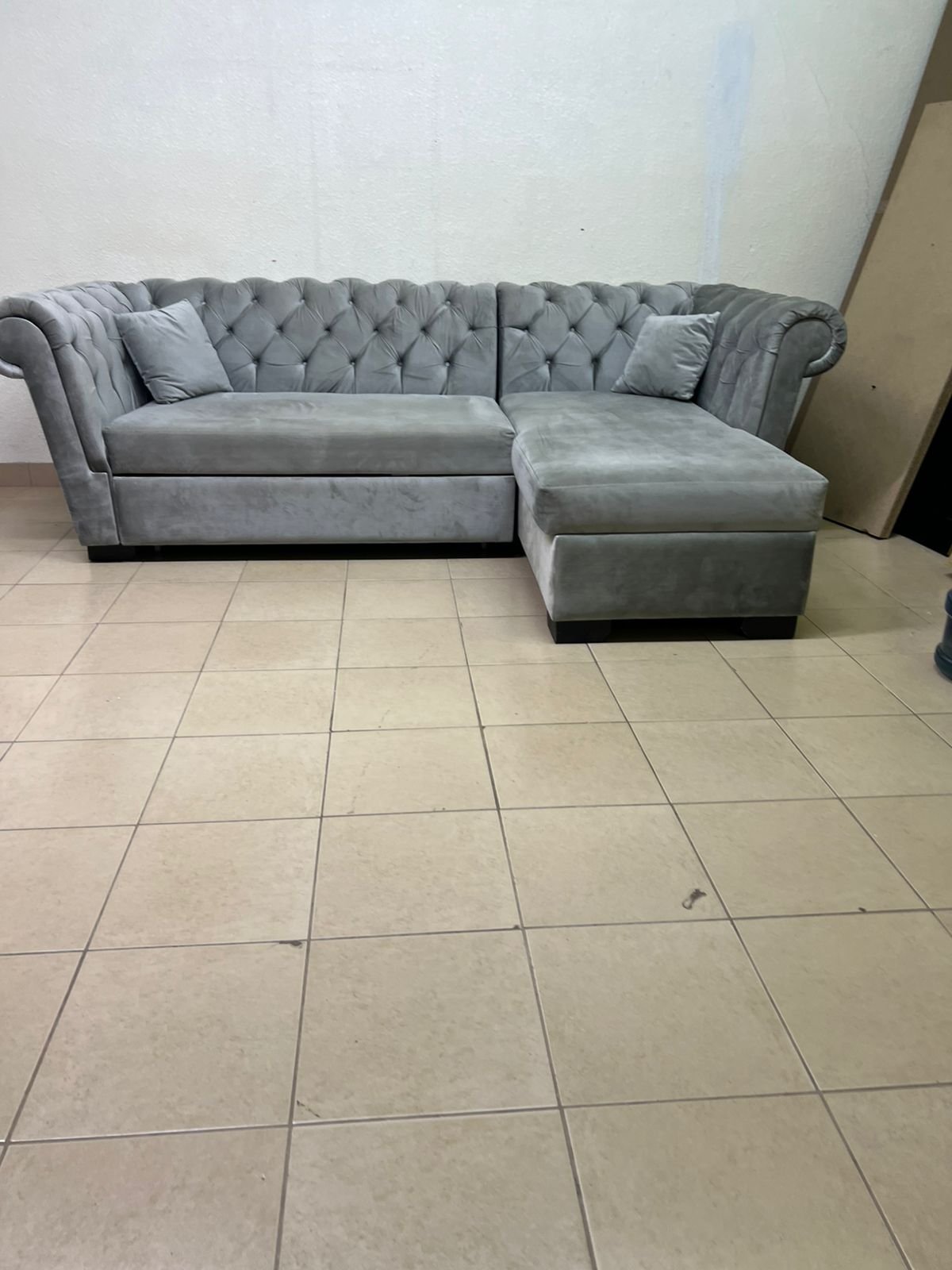 A stylish L-shaped gray sofa with internal storage space and a practical pull-out bed. - Image 2