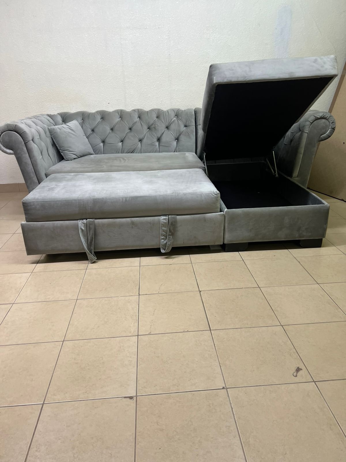 A stylish L-shaped gray sofa with internal storage space and a practical pull-out bed. - Image 3