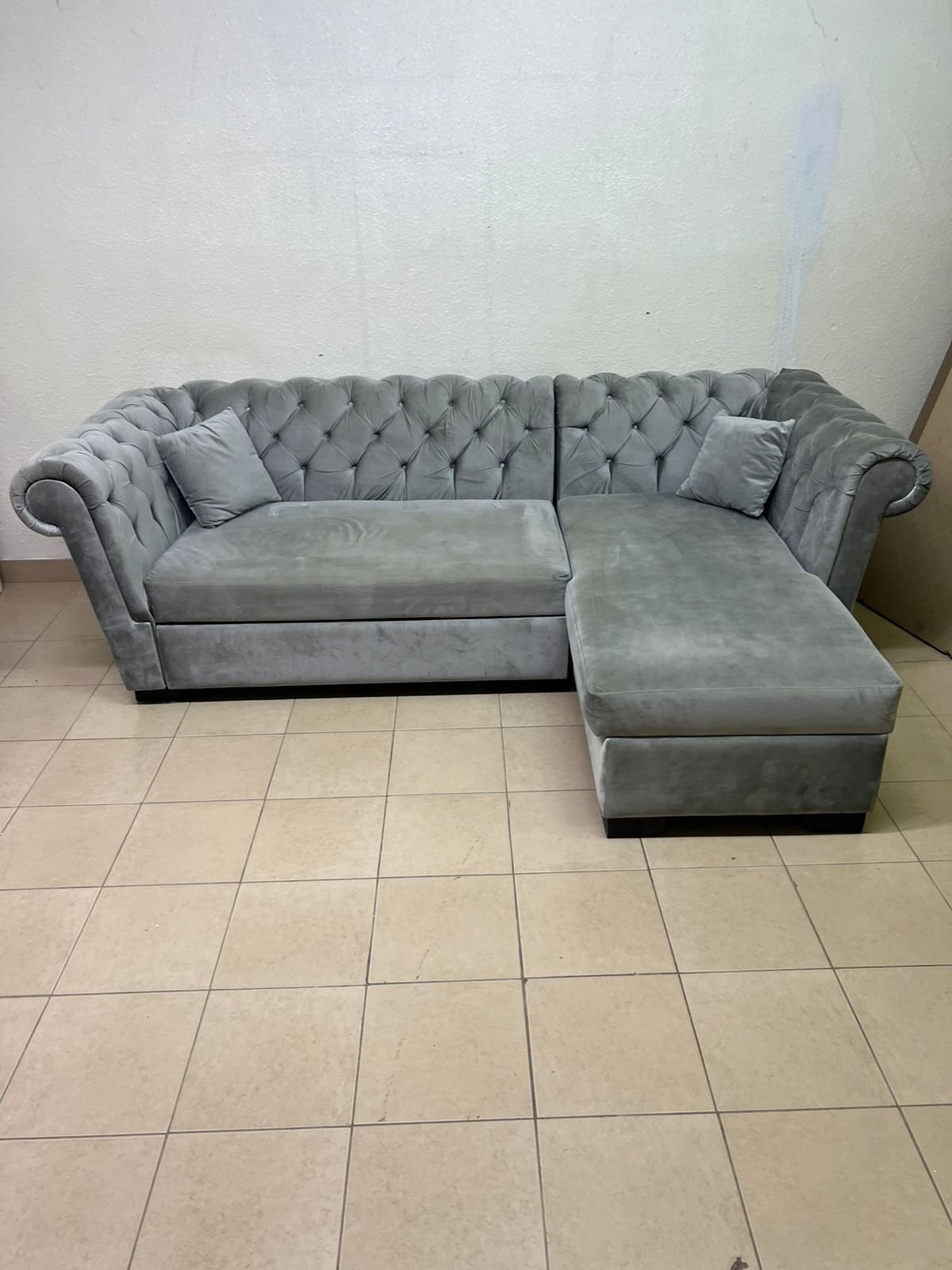 A stylish L-shaped gray sofa with internal storage space and a practical pull-out bed.