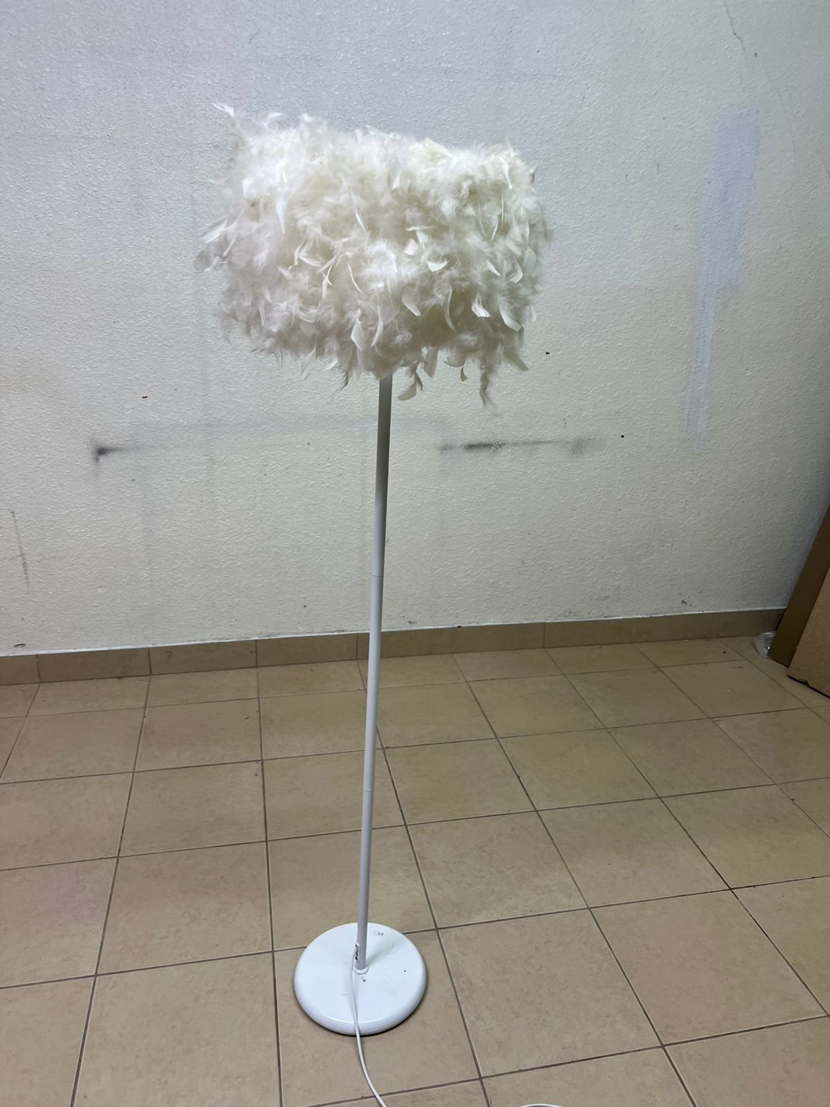 A modern floor lamp featuring a stylish cylindrical shade made of soft white feathers with a white metal base and pole. - Image 2
