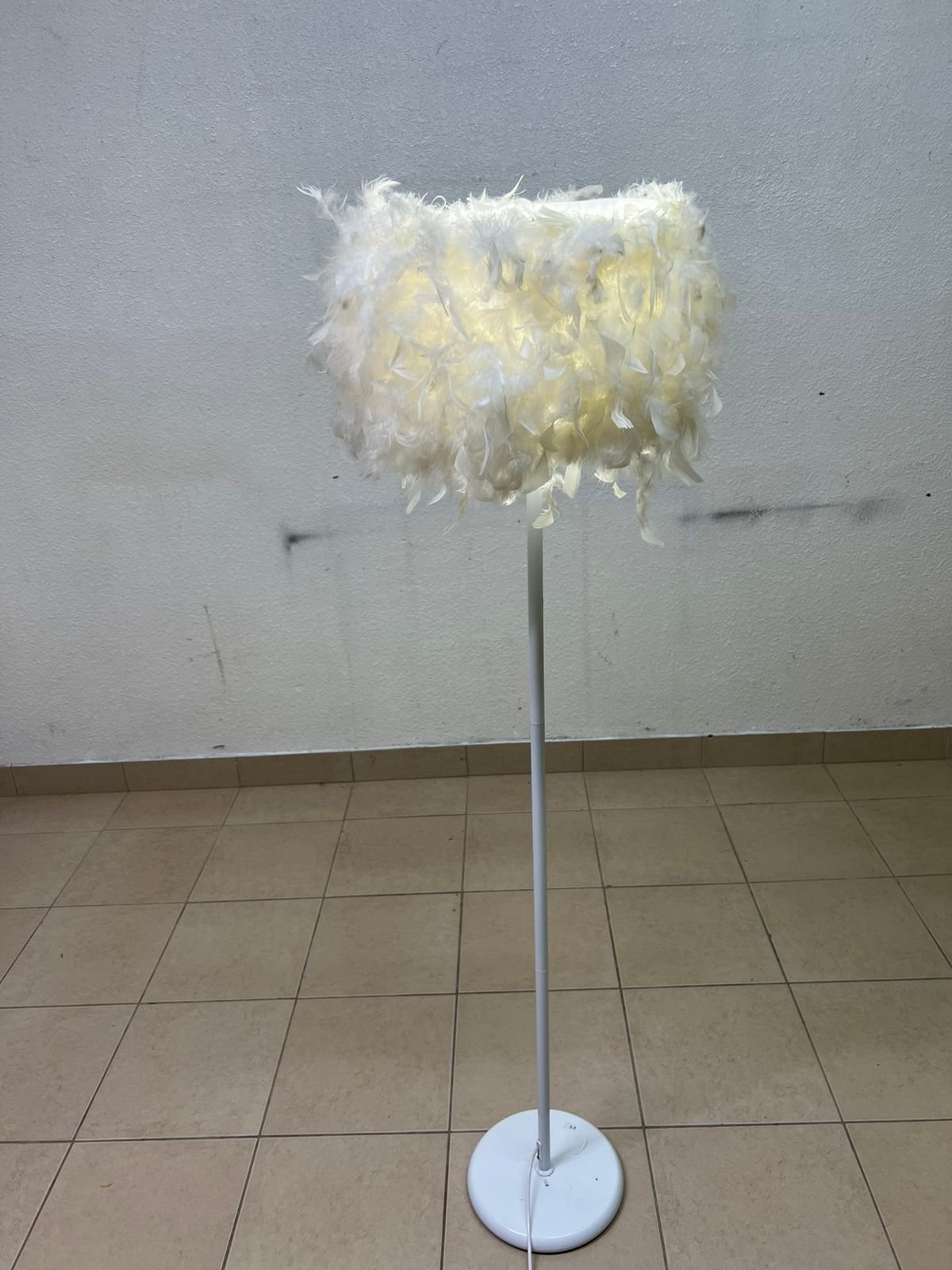 A modern floor lamp featuring a stylish cylindrical shade made of soft white feathers with a white metal base and pole. - Image 4