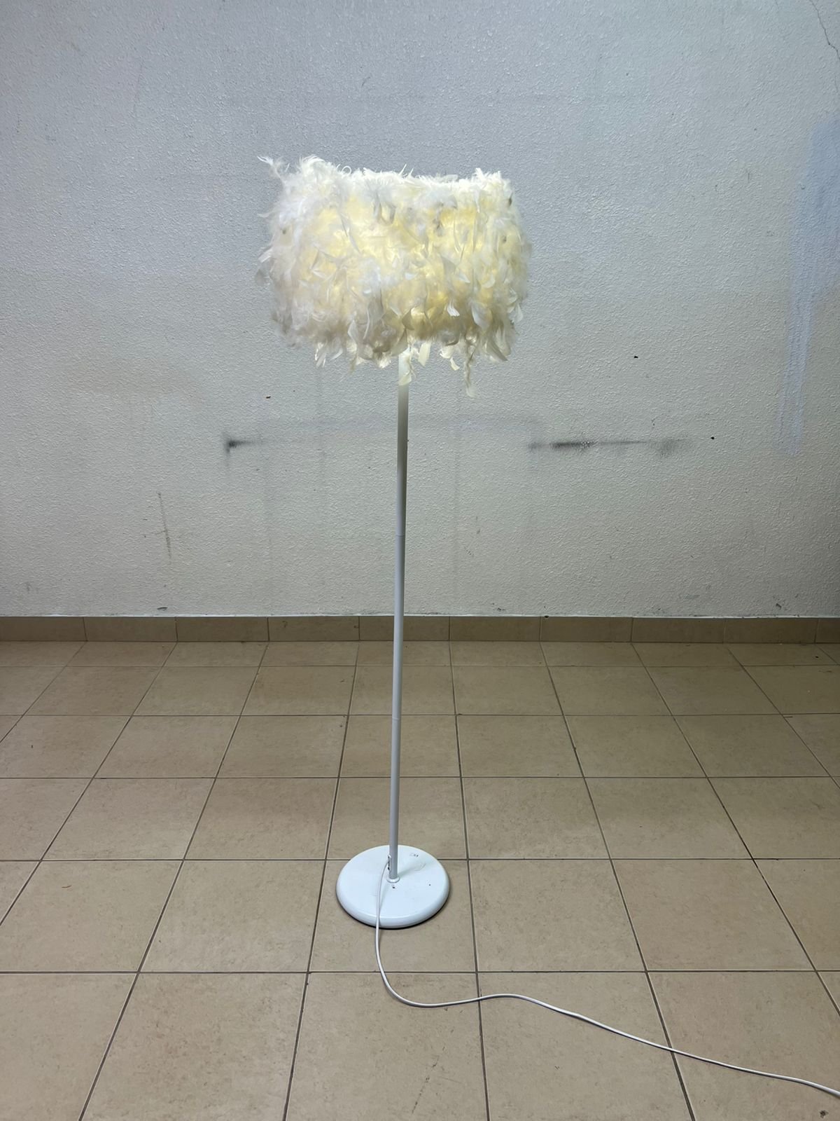 A modern floor lamp featuring a stylish cylindrical shade made of soft white feathers with a white metal base and pole. - Image 3