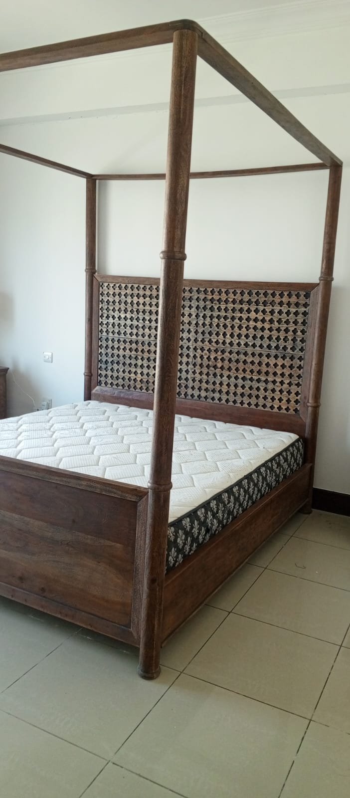 A bed, a piece of wooden furniture with a four-poster design and a headboard decorated with raised geometric patterns, along with a mattress. - Image 3