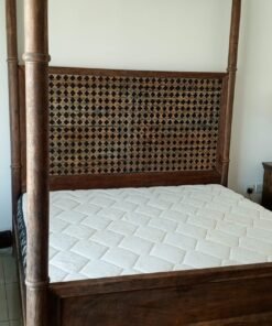 A bed, a piece of wooden furniture with a four-poster design and a headboard decorated with raised geometric patterns, along with a mattress. - Image 2