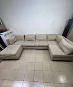A spacious, modern, U-shaped sectional sofa in a calm beige color with a footrest. - Image 7